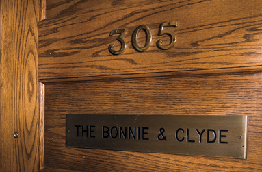 Wooden door with numbers 305 and a plaque reading 'The Bonnie & Clyde'.