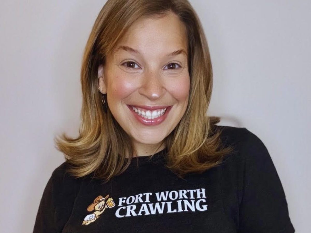 Smiling person in a 'Fort Worth Crawling' shirt against a plain background.